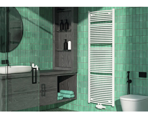 Badezimmer mit Waschtisch, Spiegel, Handtuchwärmer und Toilette vor grün gefliester Wand