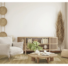 Wohnzimmer mit Sessel, Anrichte und Dekorationen im hellen Design