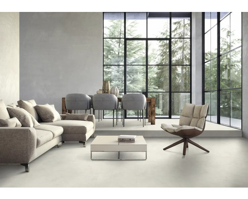 Helles Wohnzimmer mit Sofa, Stühlen, Tisch und großem Fenster mit Blick auf Bäume