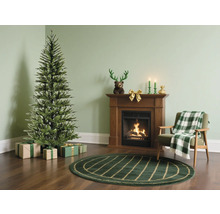 Wohnzimmer mit einem Weihnachtsbaum, Geschenken, Kamin, Sessel und Teppich