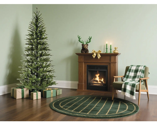 Wohnzimmer mit einem Weihnachtsbaum, Geschenken, Kamin, Sessel und Teppich