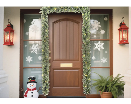 Dekorierter Hauseingang mit Tannengirlande, Laternen und Schneemann