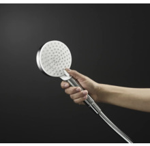 Hand die einen runden Duschkopf aus Metall hält