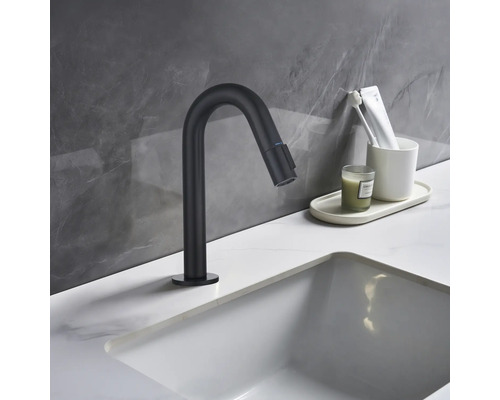 Schwarzer Waschtischmischer neben Waschbecken und Badaccessoires