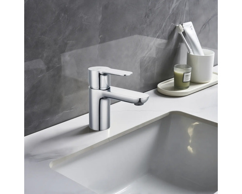 Glänzender Wasserhahn am Waschbecken im Badezimmer.