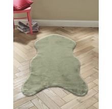 Dekofell auf Holzboden mit Stuhl und Zeitschriften im Hintergrund