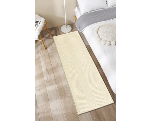 Beige Läufer vor einem Bett auf Holzboden