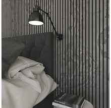 Schlafzimmer mit Bett, Wandleuchte und Wandpaneelen