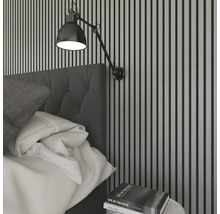 Schlafzimmer mit Bett, Wandleuchte und Nachttisch mit Buch