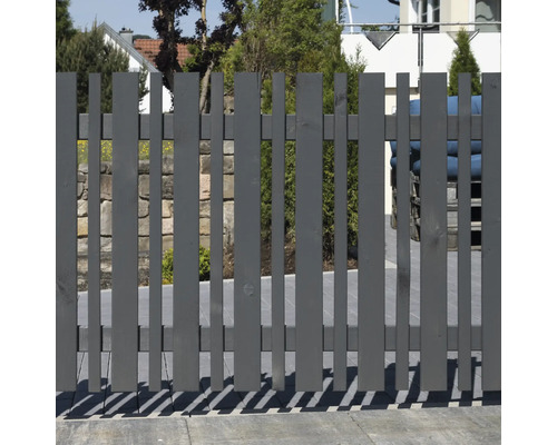Grauer Holzzaun mit vertikalen Latten im Garten