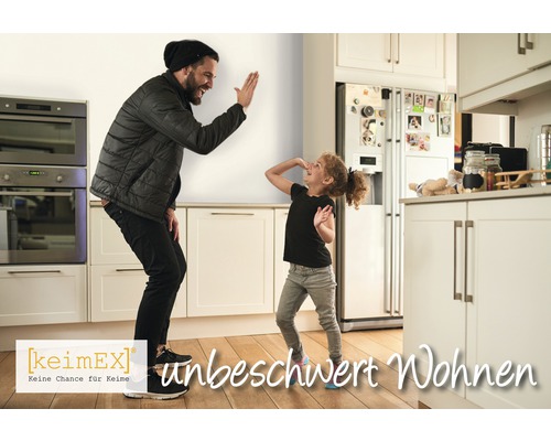 "Vater und Tochter geben sich in einer hellen Küche ein High Five