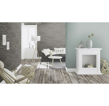 Wohnzimmer mit Sofa, Tisch, Lampe, Kamin, Sessel und Holzboden
