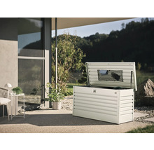 Geöffnete Gartenbox aus Metall auf einer Terrasse mit Gartenblick