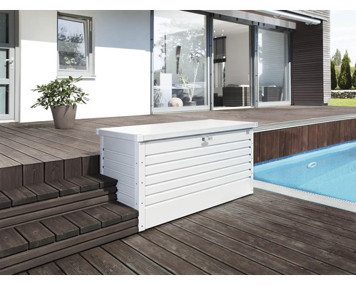 Aufnahme einer weißen Gerätebox aus Metall auf einer Terrasse neben einem Swimmingpool.