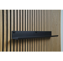 Schwarzes Wandregal an einer Holzpaneelwand