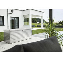 Außenaufnahme mit einer silberfarbenen Aufbewahrungsbox aus Metall auf einer Terrasse.