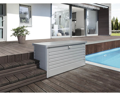 Aufnahme einer grauen Gerätebox aus Metall auf einer Holzterrasse neben einem Pool.