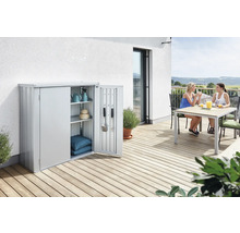 Metall Geräteschrank mit geöffneter Tür auf einer Terrasse mit zwei Frauen an einem Tisch