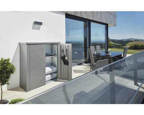 Terrassenschrank Biohort Romeo L High 132 x 87 x 181 cm quarzgrau-metallic Metall Gartenschrank mit geöffneten Türen auf einer Terrasse