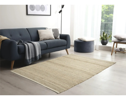 Wohnzimmer mit Sofa, Hocker und Teppich mit Fischgrätenmuster