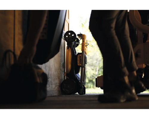 Zusammengeklappter DeWalt Arbeitsstrahler mit Transporträdern, aufbewahrt in einer Werkstatt