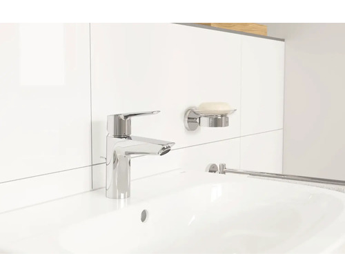 Waschbecken mit Armatur, Seifenschale und Handtuchhalter in einem hellen Badezimmer