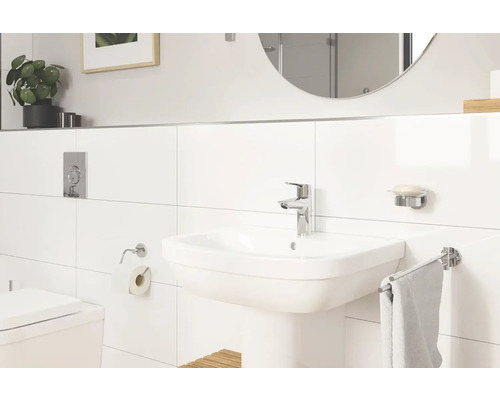 Modernes Badezimmer mit Waschbecken, Armatur, Spiegel und Accessoires.