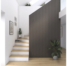 Heller Flur mit Treppe, Wandpaneelen und Zimmerpflanzen.