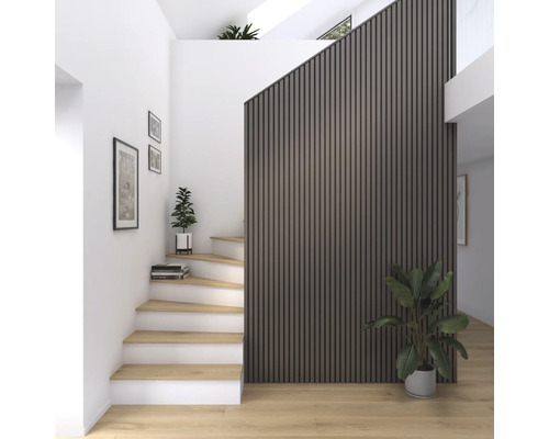 Heller Flur mit Treppe, Wandpaneelen und Zimmerpflanzen.