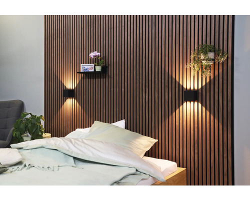Schlafzimmer mit Holzpaneelwand, Wandleuchten, Regal mit Dekoration und Bett