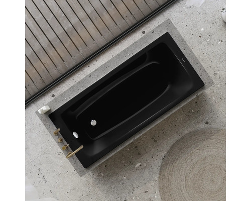 Schwarze Badewanne im Badezimmer mit Holzbalkendecke und Steinboden