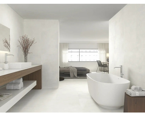 Helles Badezimmer mit Badewanne, Waschtisch und Zugang zum Schlafzimmer