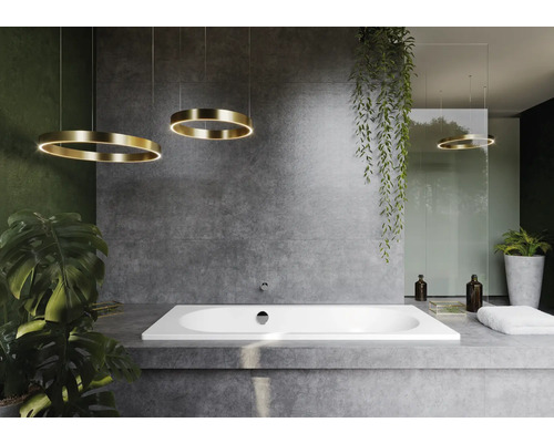 Modernes Badezimmer mit Badewanne, Betonwand und kreisförmigen Hängeleuchten