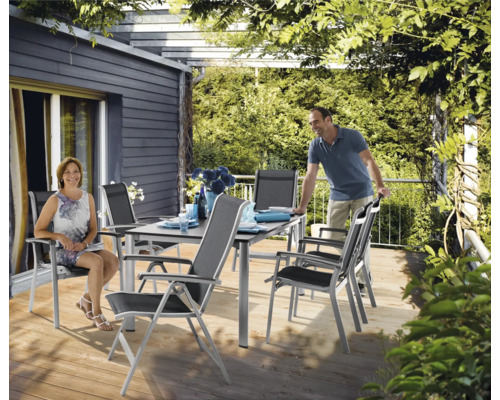 Esstischgruppe mit Tisch und Stühlen auf einer Terrasse unter einer Pergola.
