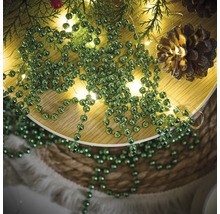 Dekoration mit Tannenzweigen, Lichterkette, Tannenzapfen und grüner Kugelkette