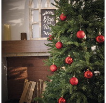 Geschmückter Weihnachtsbaum mit roten Kugeln im Wohnzimmer.