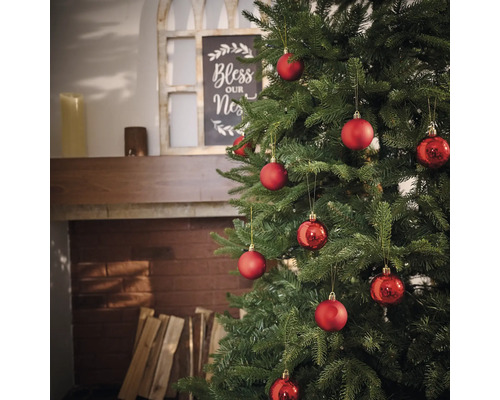 Geschmückter Weihnachtsbaum mit roten Kugeln im Wohnzimmer.