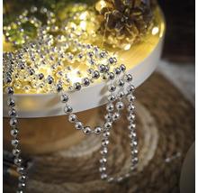 Dekoration mit silberfarbener Kugelkette auf einem Tablett