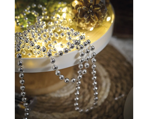 Dekoration mit silberfarbener Kugelkette auf einem Tablett