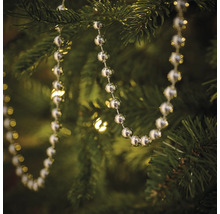 Silberfarbene Kugelkette als Baumschmuck an einem Weihnachtsbaum
