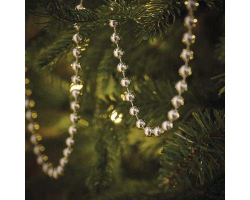 Silberfarbene Kugelkette als Baumschmuck an einem Weihnachtsbaum