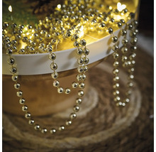 Goldfarbene Perlenkette zur Dekoration in einer Schale