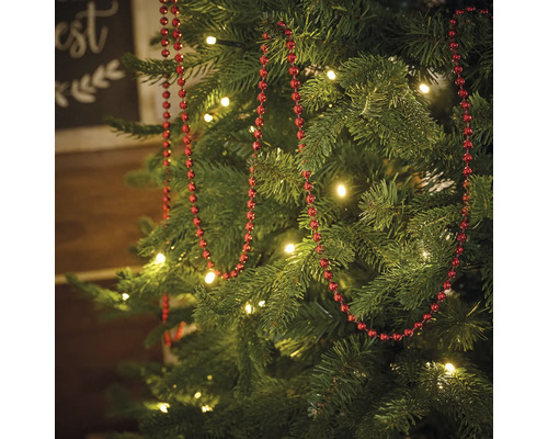 Geschmückter Weihnachtsbaum mit roter Perlenkette und Beleuchtung