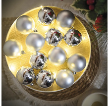 Dekoration mit silberfarbenen Weihnachtskugeln auf einem beleuchteten Tablett