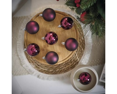 Dekorative Weihnachtskugeln auf einem Holzteller