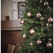 Geschmückter Weihnachtsbaum mit Christbaumkugeln vor einem Kamin