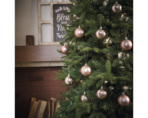 Geschmückter Weihnachtsbaum mit Christbaumkugeln vor einem Kamin