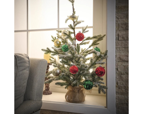 Dekorierter künstlicher Weihnachtsbaum auf Fensterbank