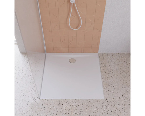 Quadratische Duschwanne aus Kunststein mit Ablaufgarnitur in einer Dusche.