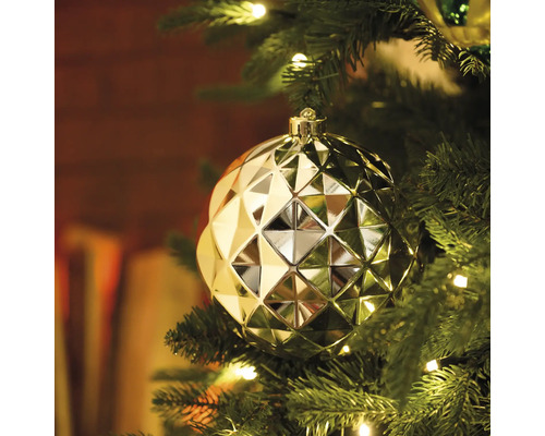 Goldene Weihnachtskugel mit geometrischem Muster am Weihnachtsbaum